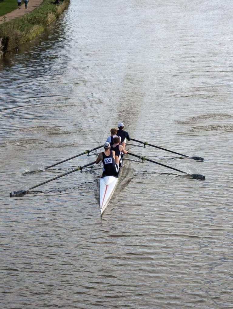 Men's coxless four racing towards the railway bridge